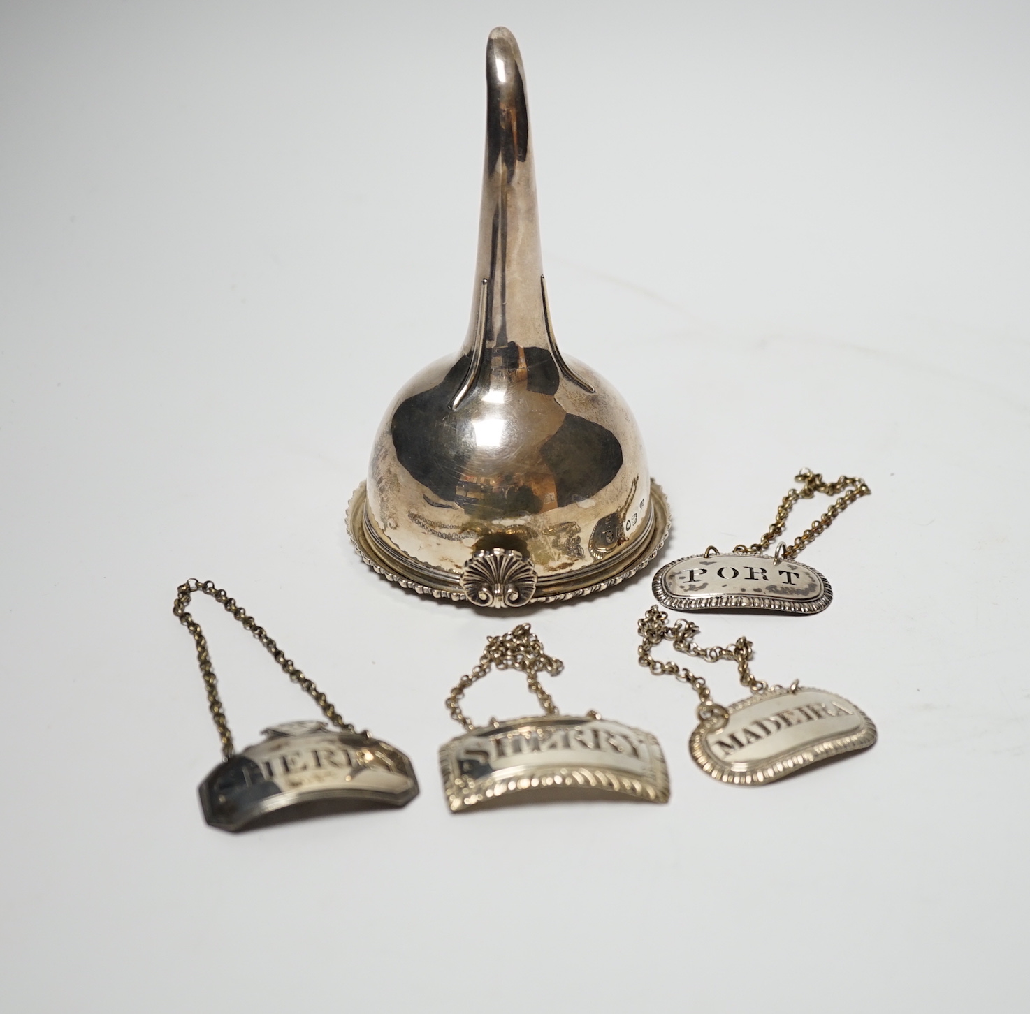 A George IV silver wine funnel, London, 1825, 12.9cm and four George III silver wine labels including pair by Phipps & Robinson, London, 1808/9.